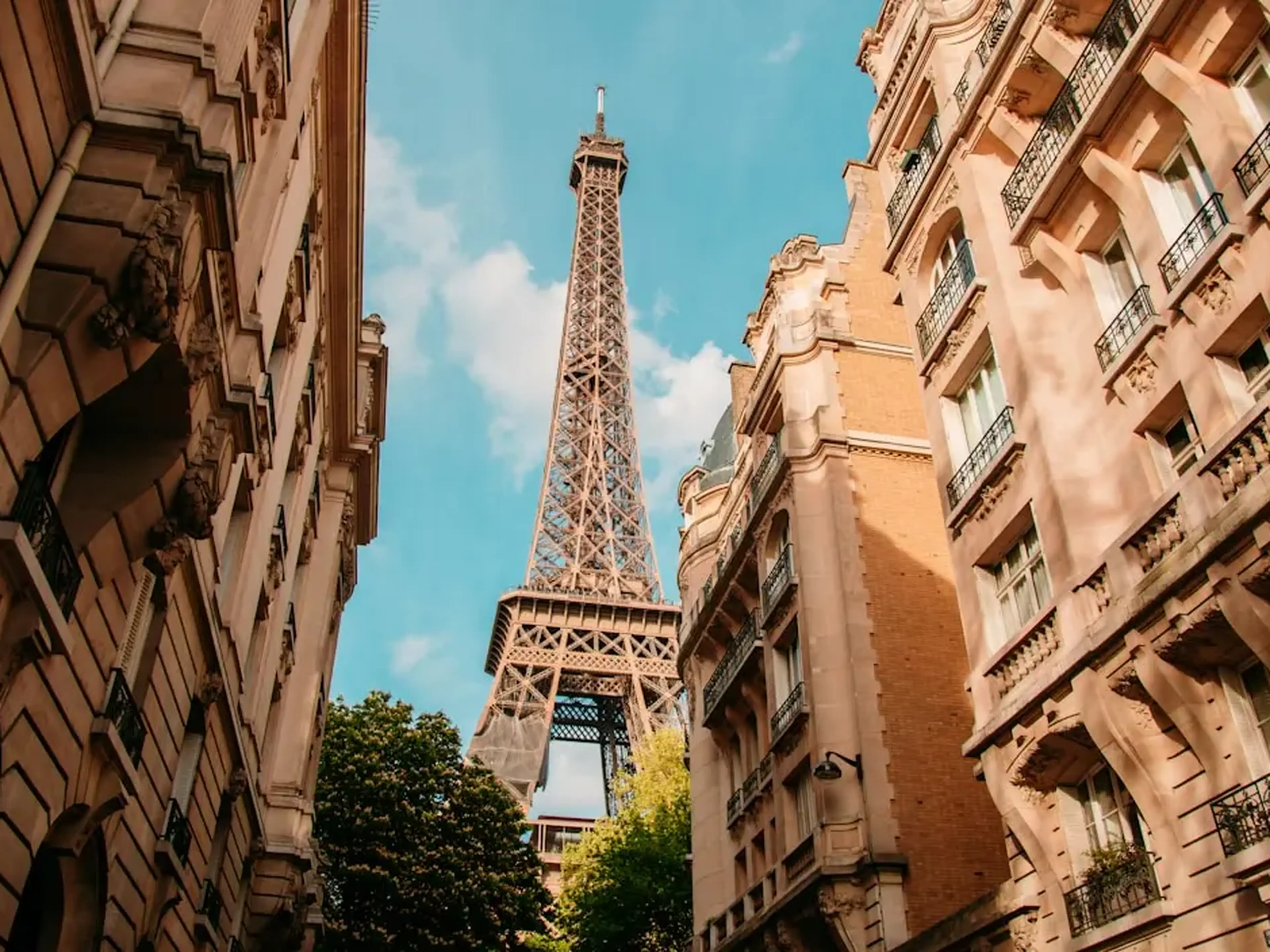 view of the eiffel tower between buildings in paris