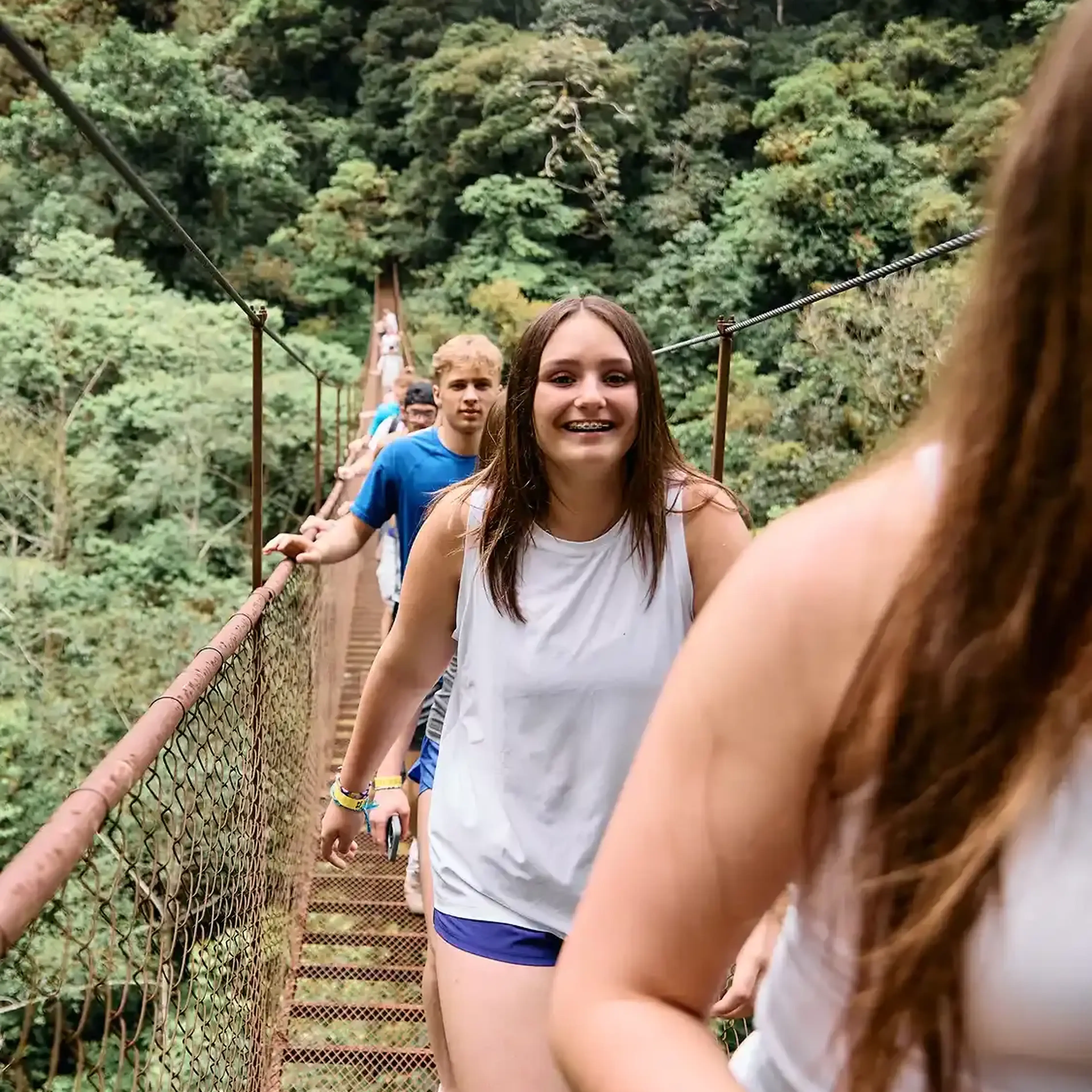 students crossing a bridge in south america