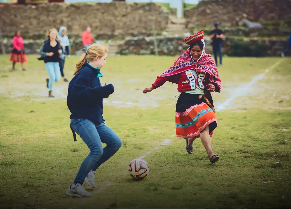 Student and local playing soccer in Peru