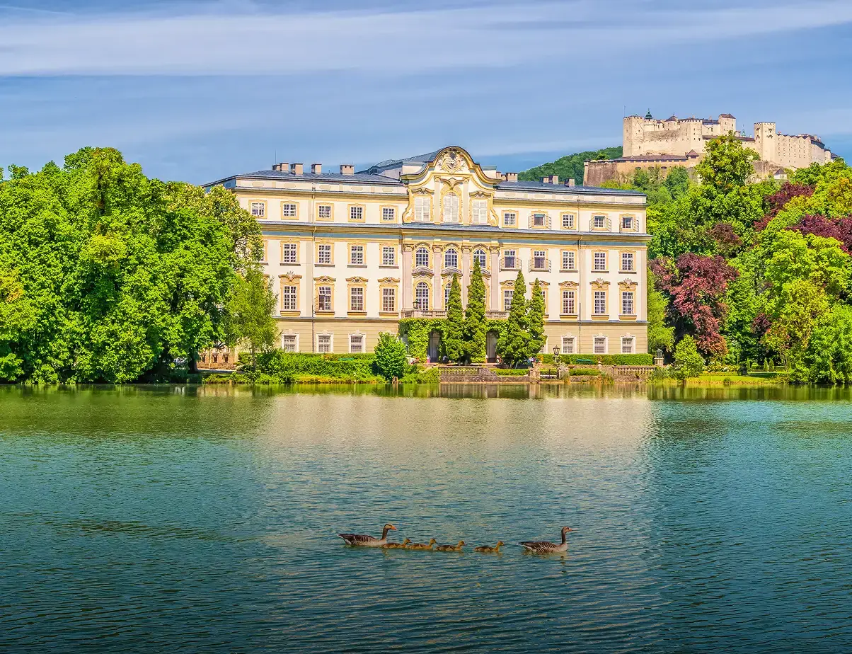 Famous Schloss Leopoldskron with Hohensalzburg Fortress in the background on a sunny day with blue sky in Salzburg, Austria