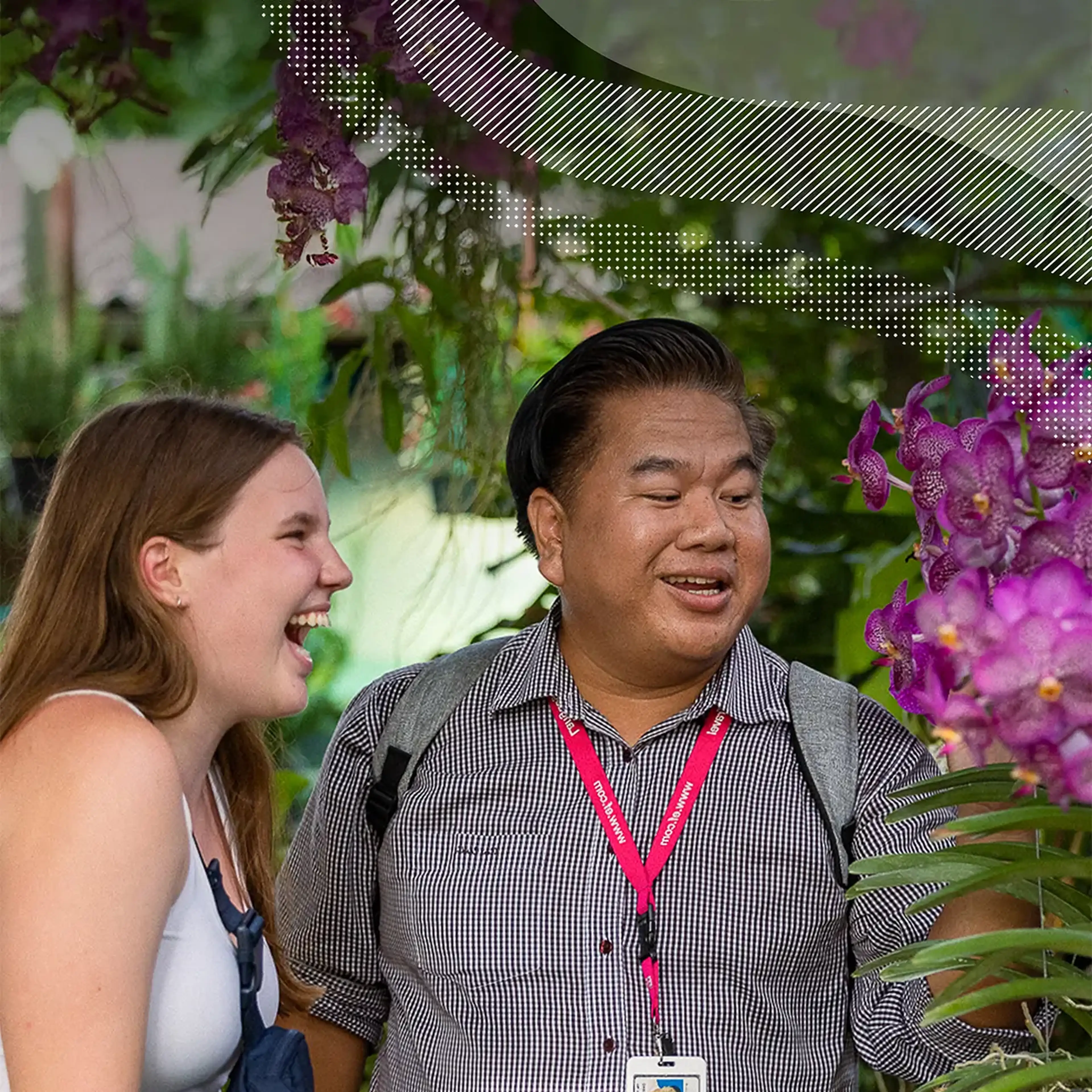 Tour Director showing vibrant purple flowers to traveler in Thailand
