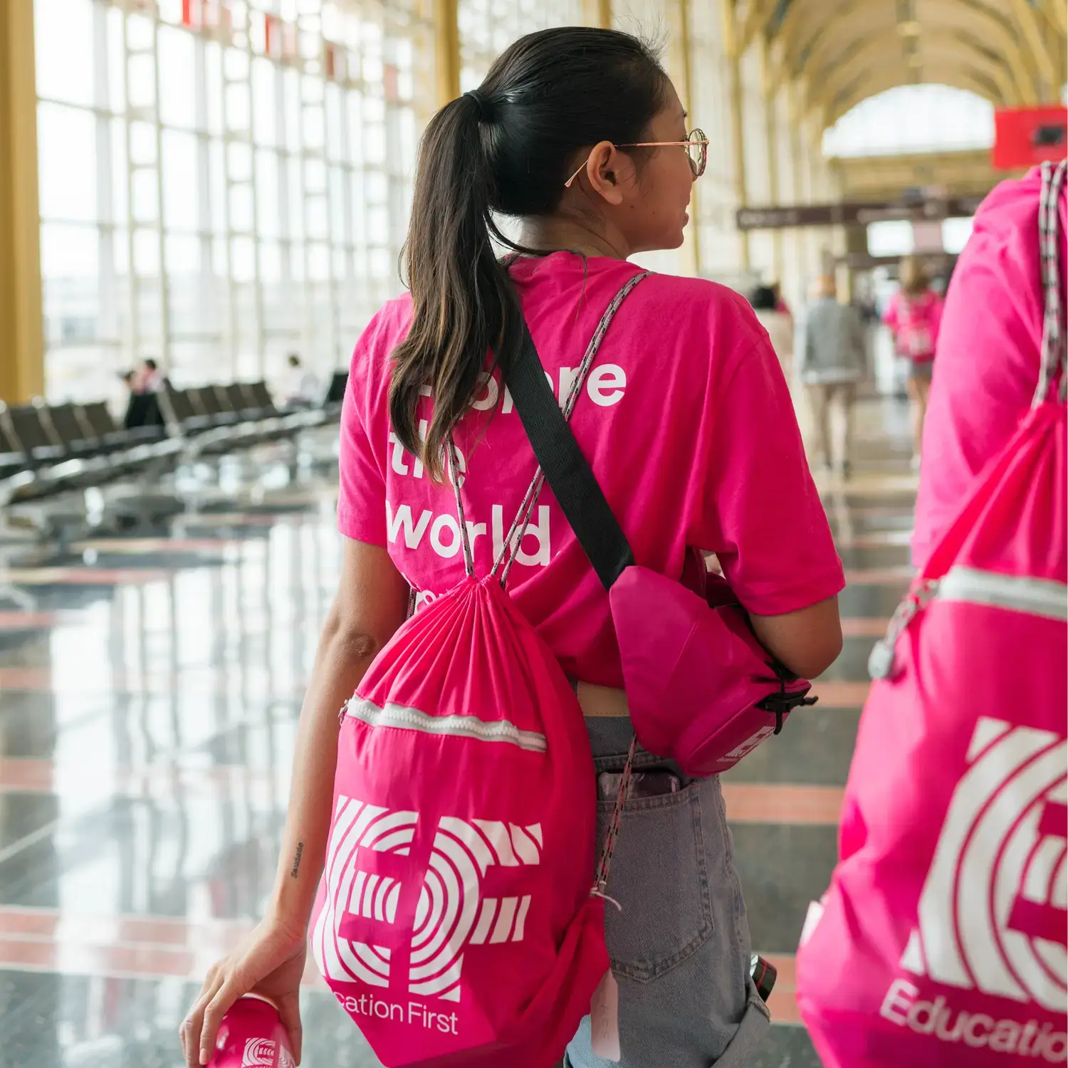 EF staff walking through an airport with pink backpacks