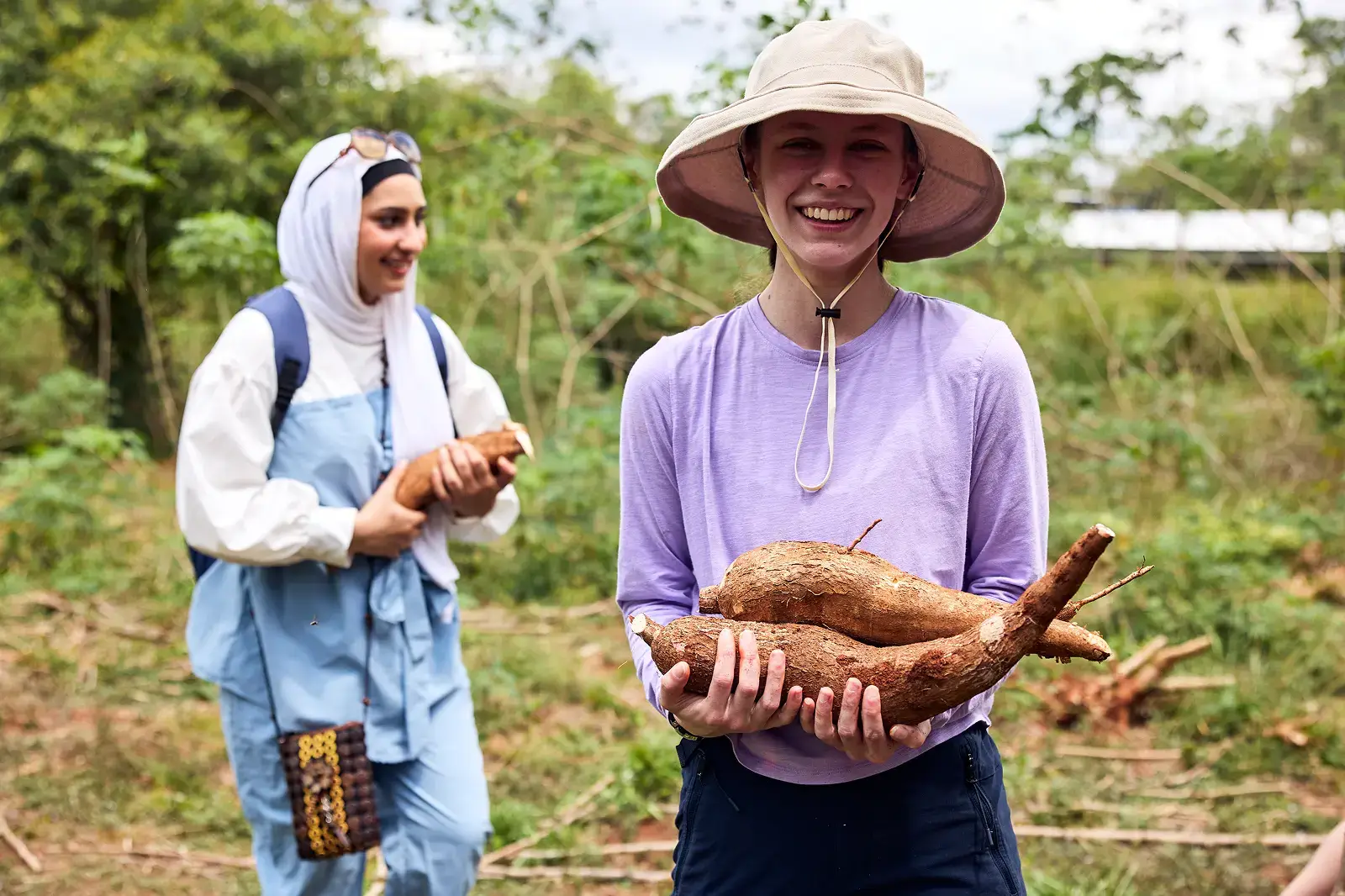 Student on local farm holding produce