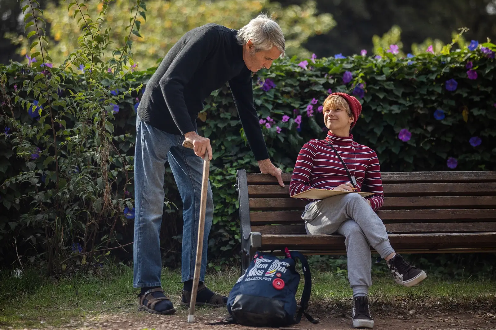 Artist talking with student drawing in park