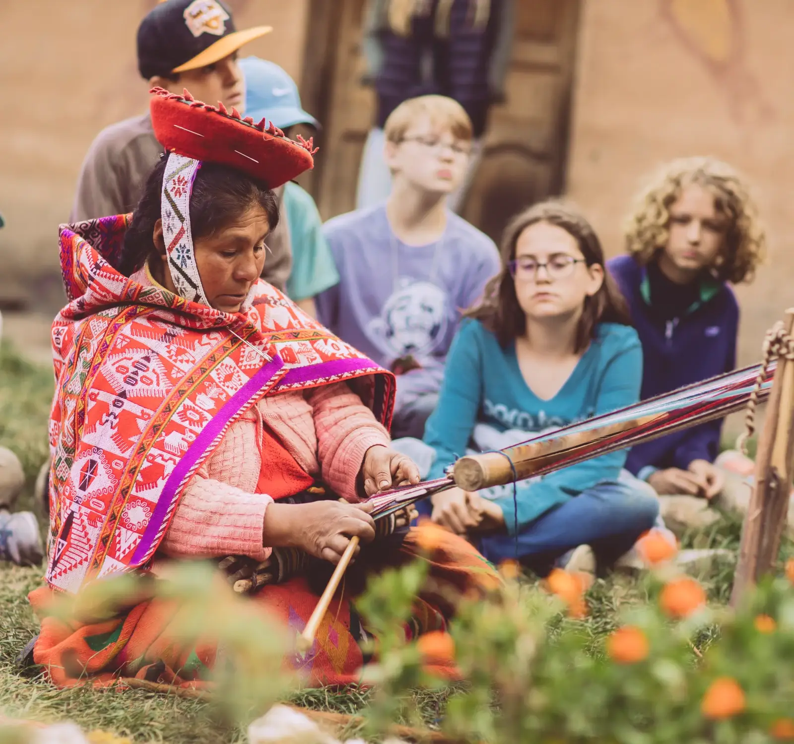 Students watch a Peruvian woman do a weaving demonstration