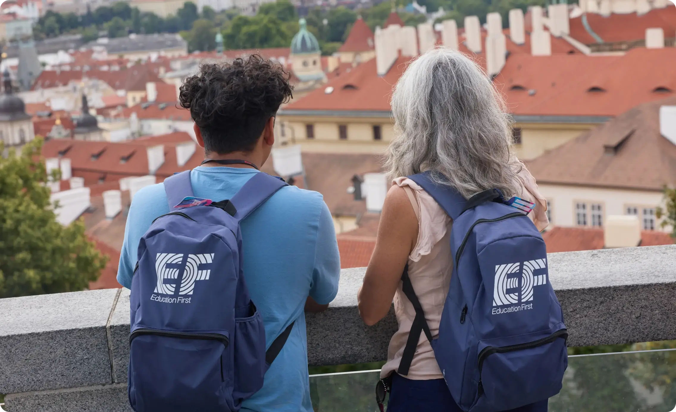 A teacher and student talk as they overlook a European city with EF backpacks on
