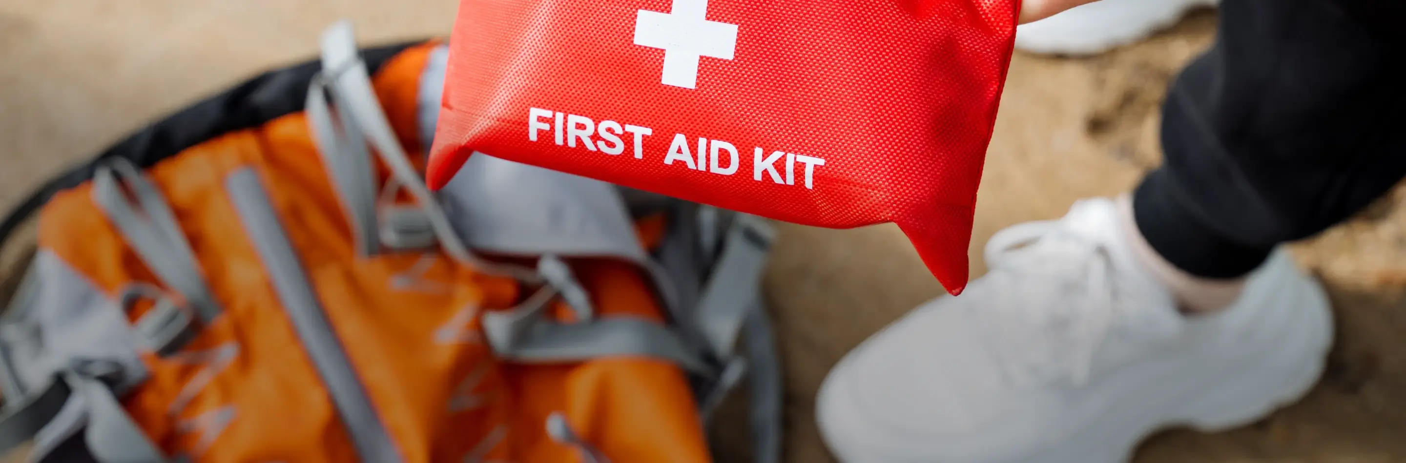 A student holding a first aid kit on the beach