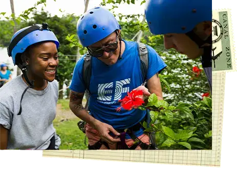 student and tour director looking at a flower