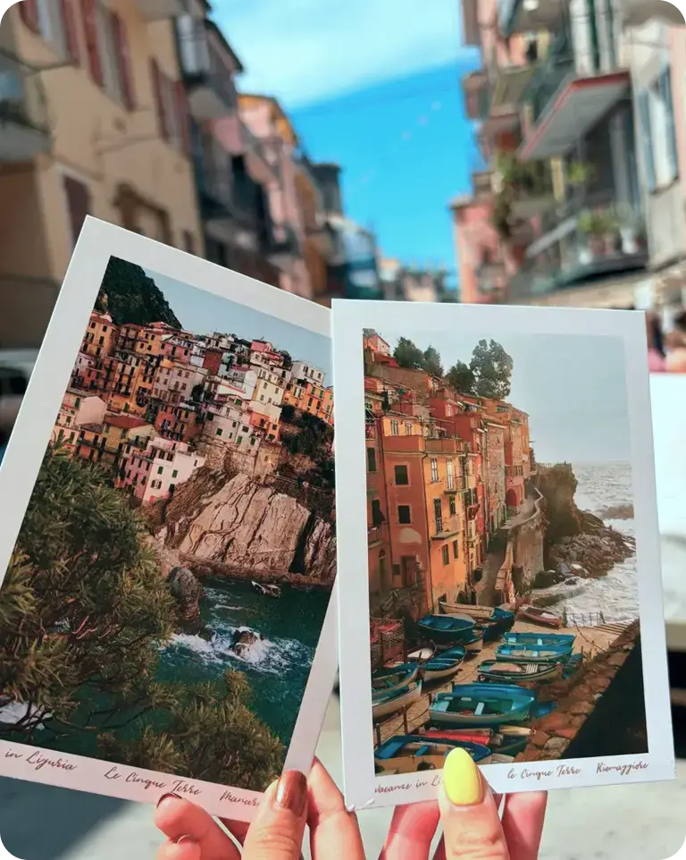 Travelers holding up postcards in Cinque Terre, Italy