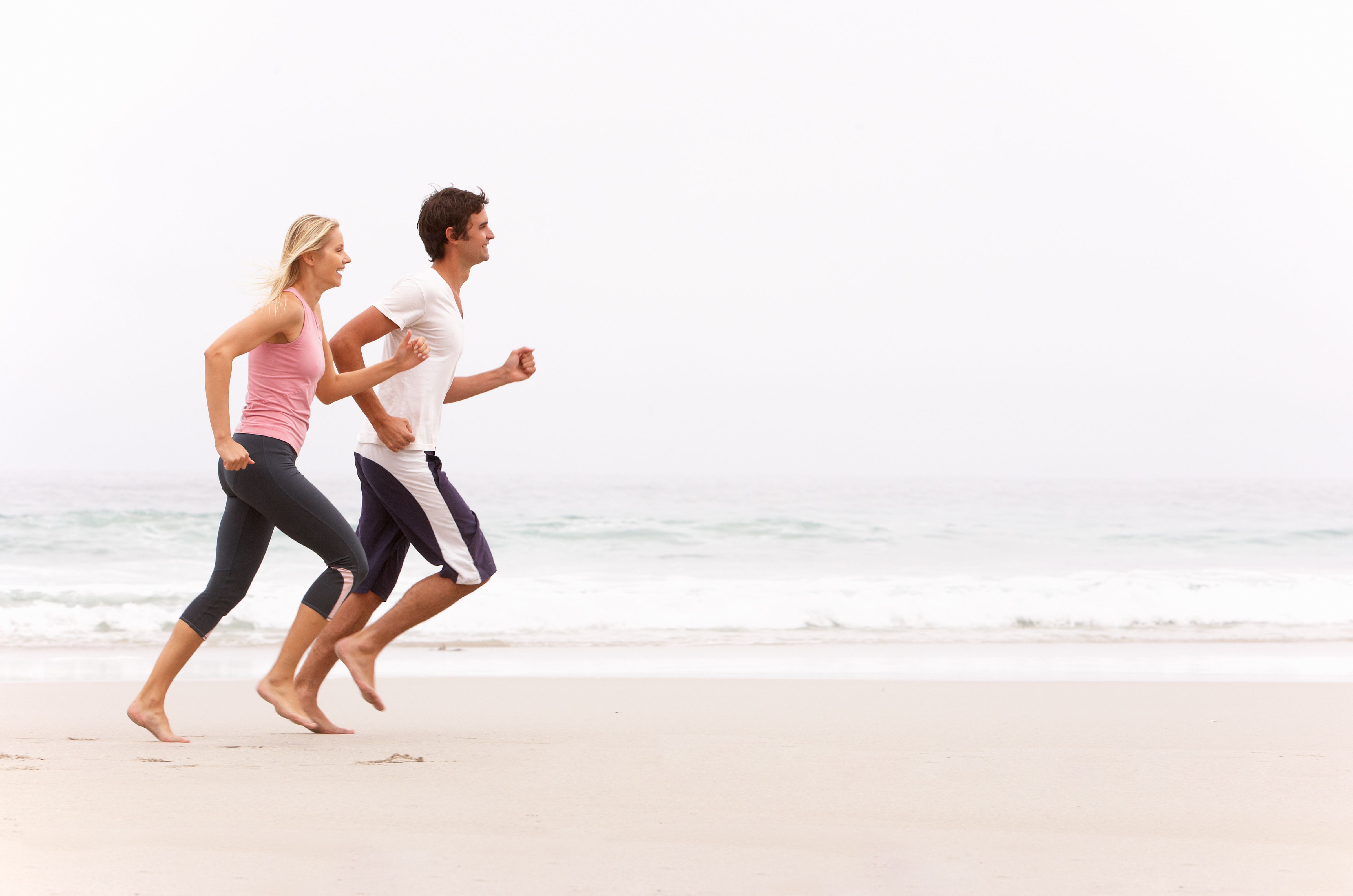 Joggen Frau und Mann, sportlich aktiv am Strand