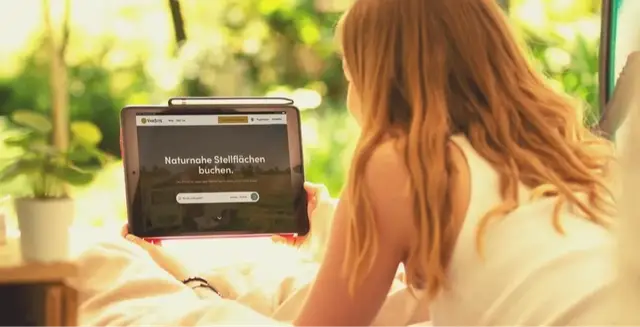 Junge Frau am Tablet im Camper.