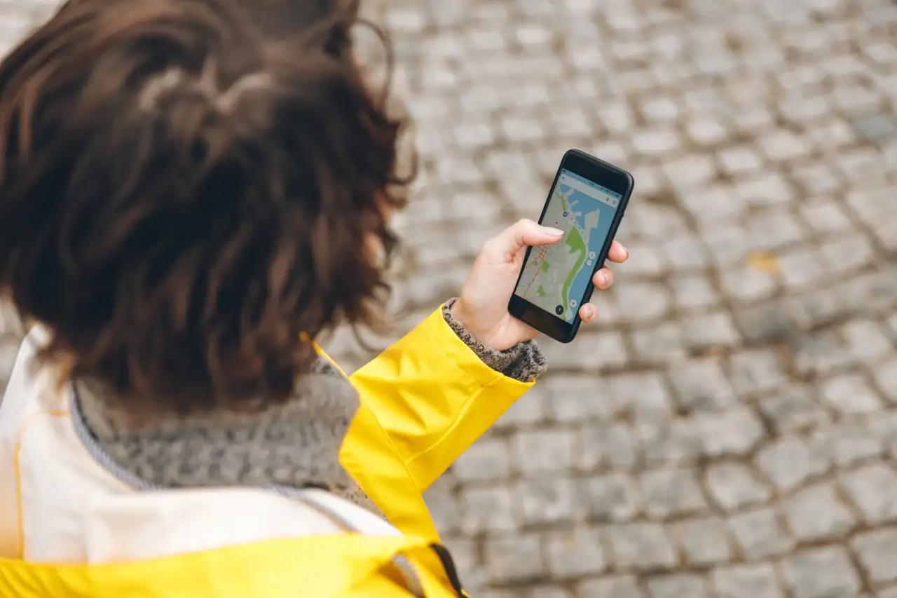 Eine Person hat eine Karte auf ihrem Smartphone geöffnet, was sie in der Hand hält