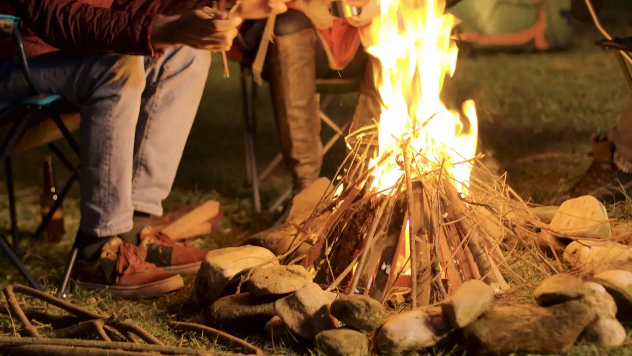Person sitzt an Lagerfeuer