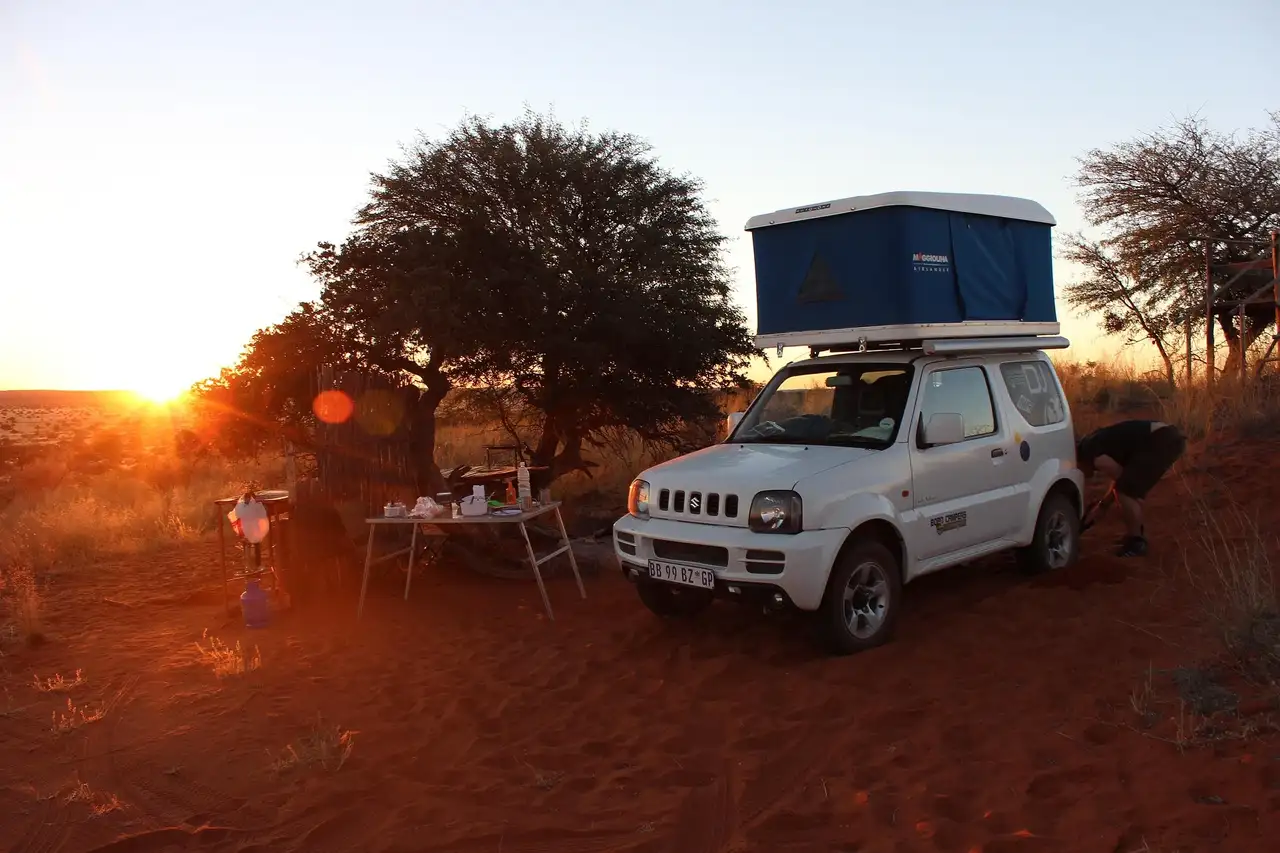 Auto mit Hartschalendachzelt auf einem Campingplatz