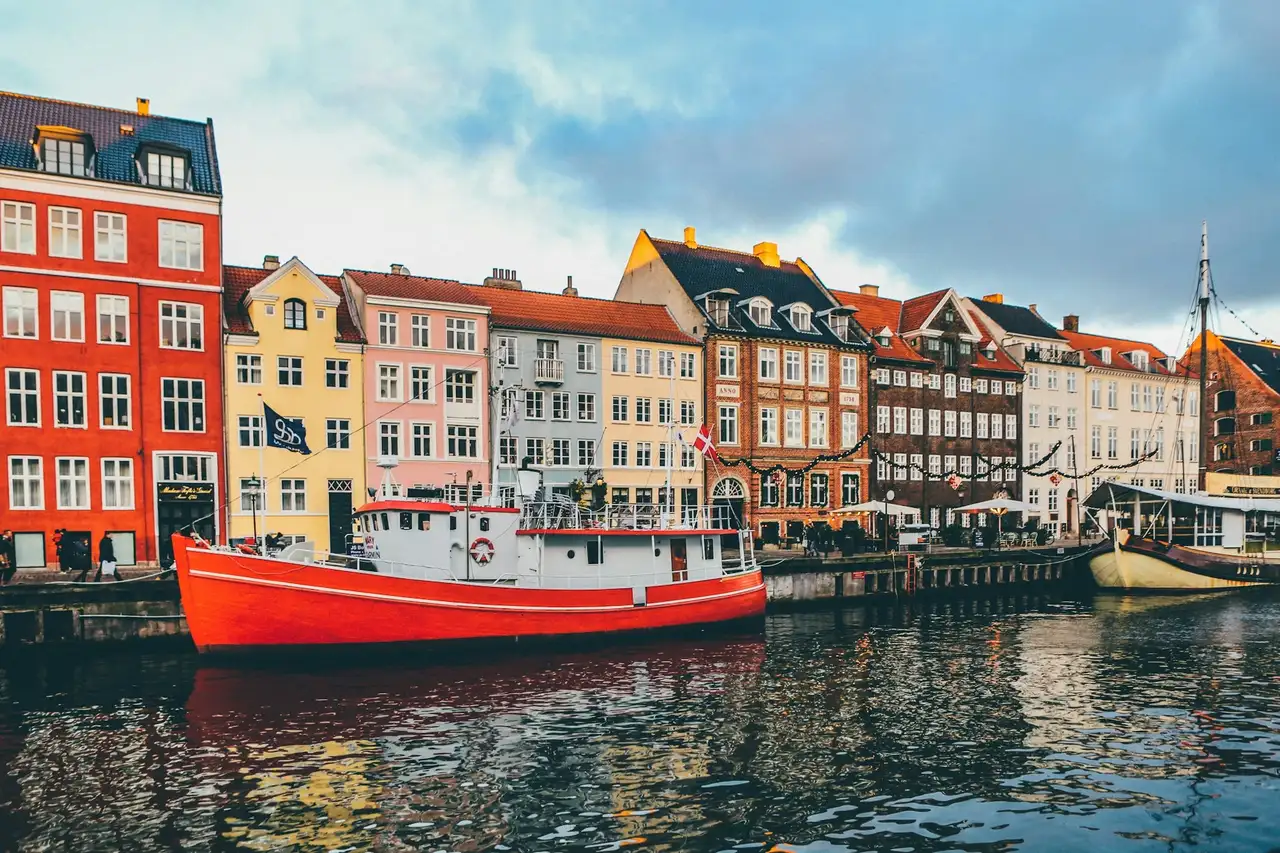 Bunte Häuser am Wasser in Kopenhagen, davor liegen Schiffe an