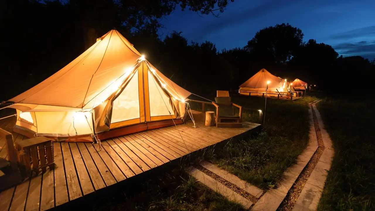 Drei Glampingzelte leuchten in der Nacht