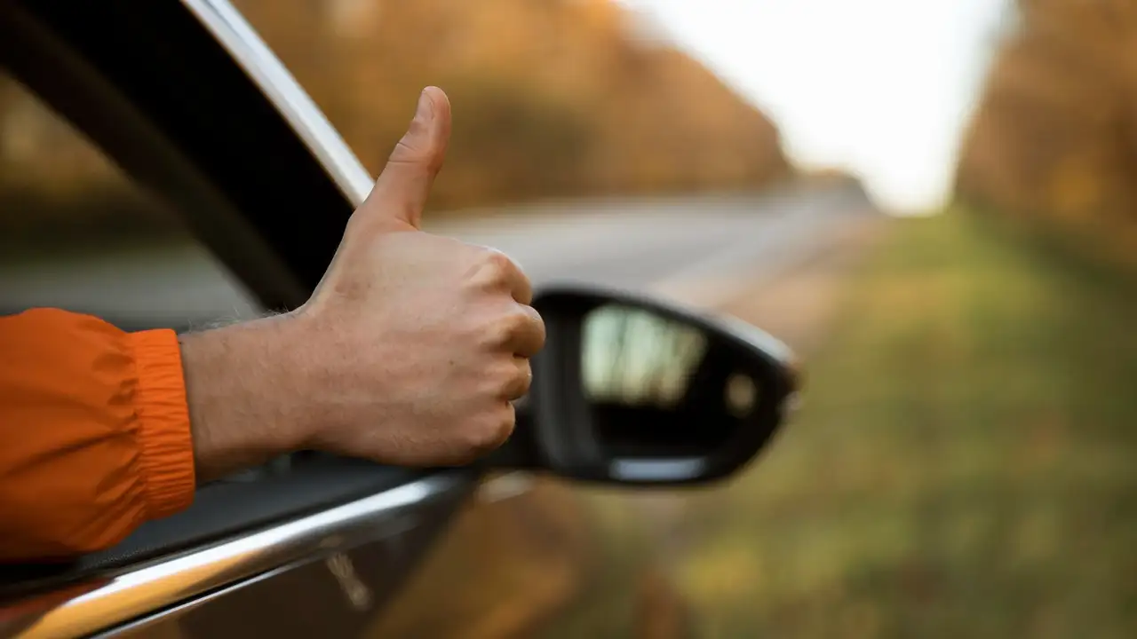 Mann streckt Daumen aus dem Wohnmobil Fenster