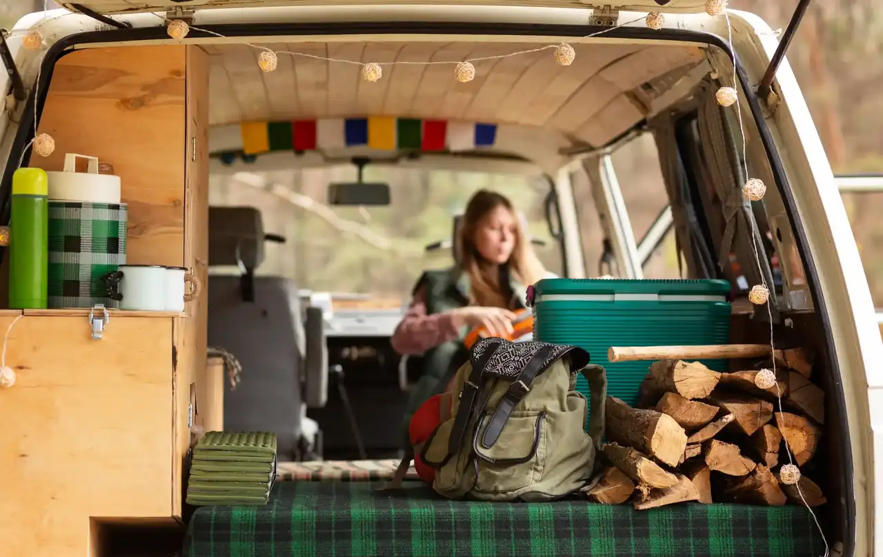 Frau sitz in einem gemütlichen Campervan mit Lichterkette