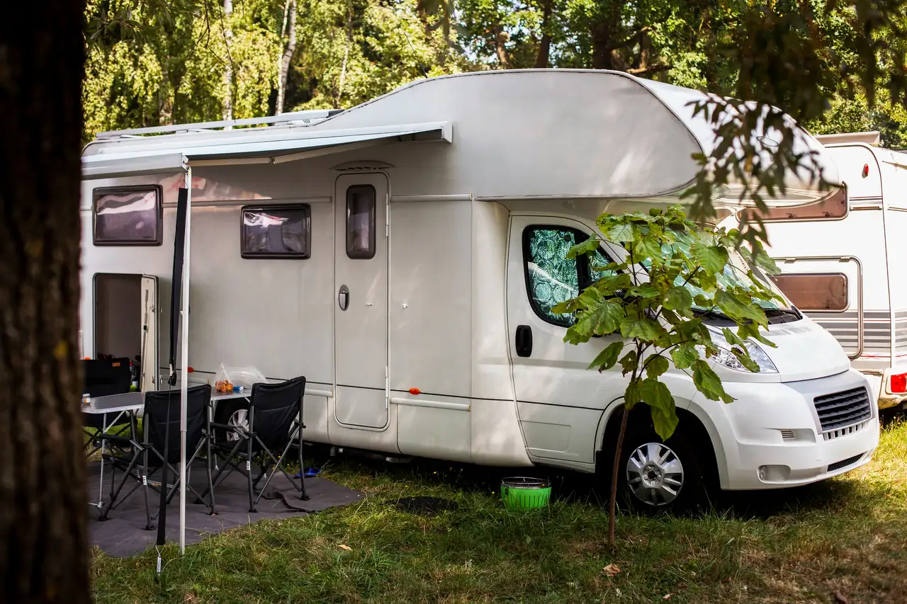 Wohnmobile in Schweden unter Bäumen