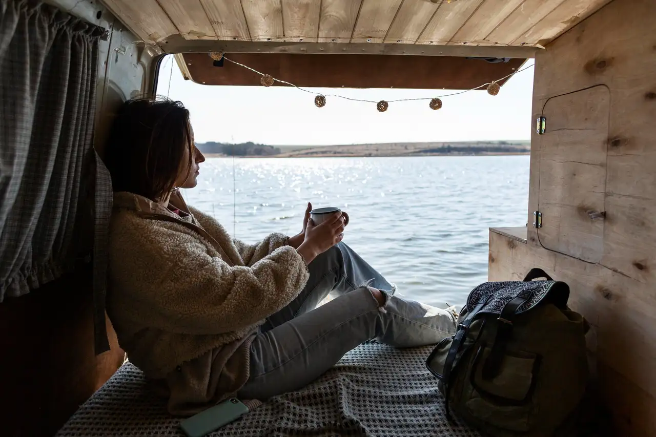 Frau im Van am Meer in Dänemark