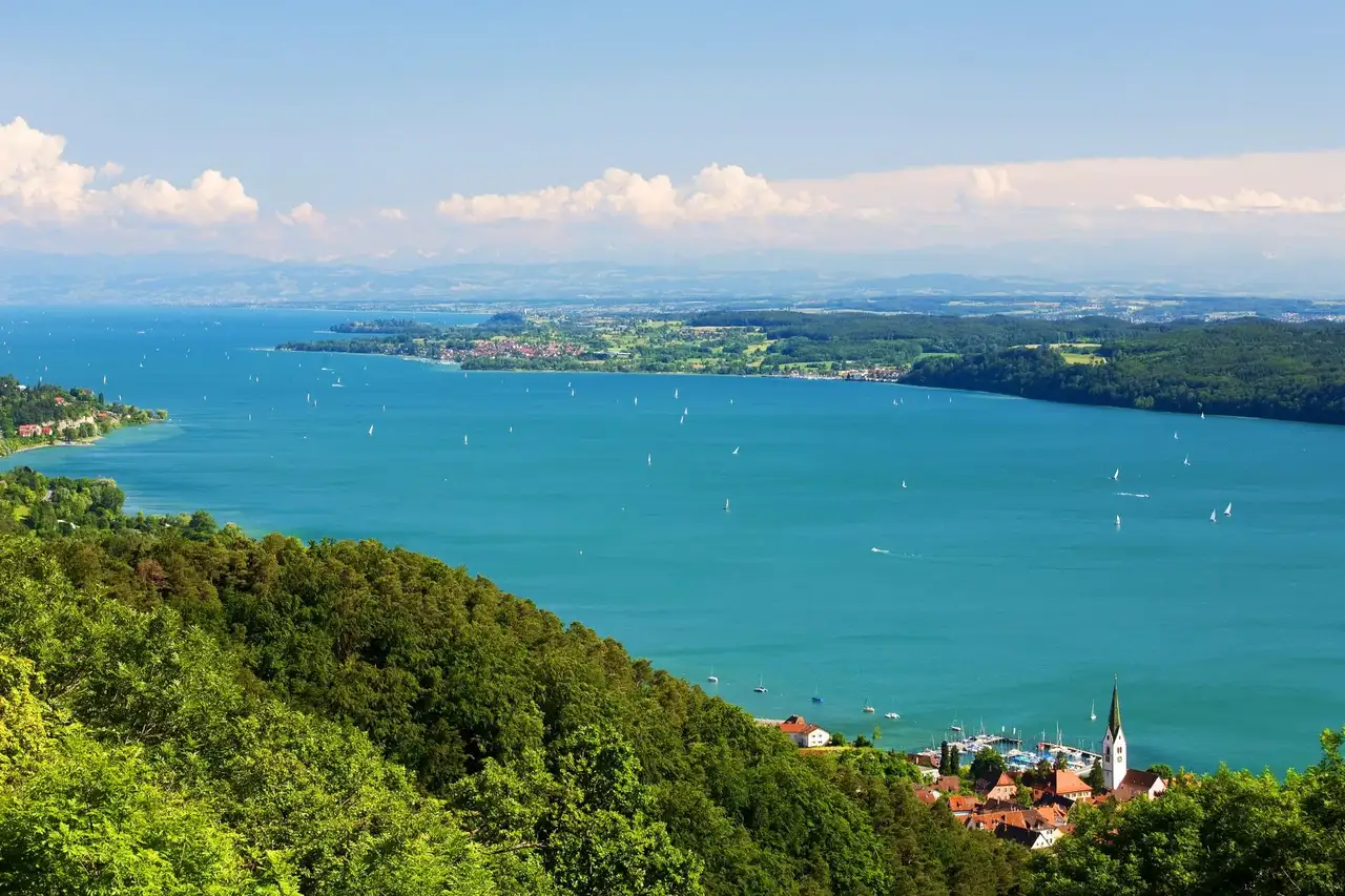 Bodensee mit Booten auf dem See und einer Stadt im Vordergrund