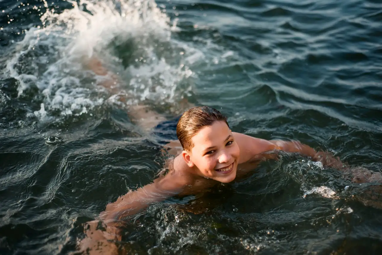 Ein Junge schwimmt in einem See im Allgäu