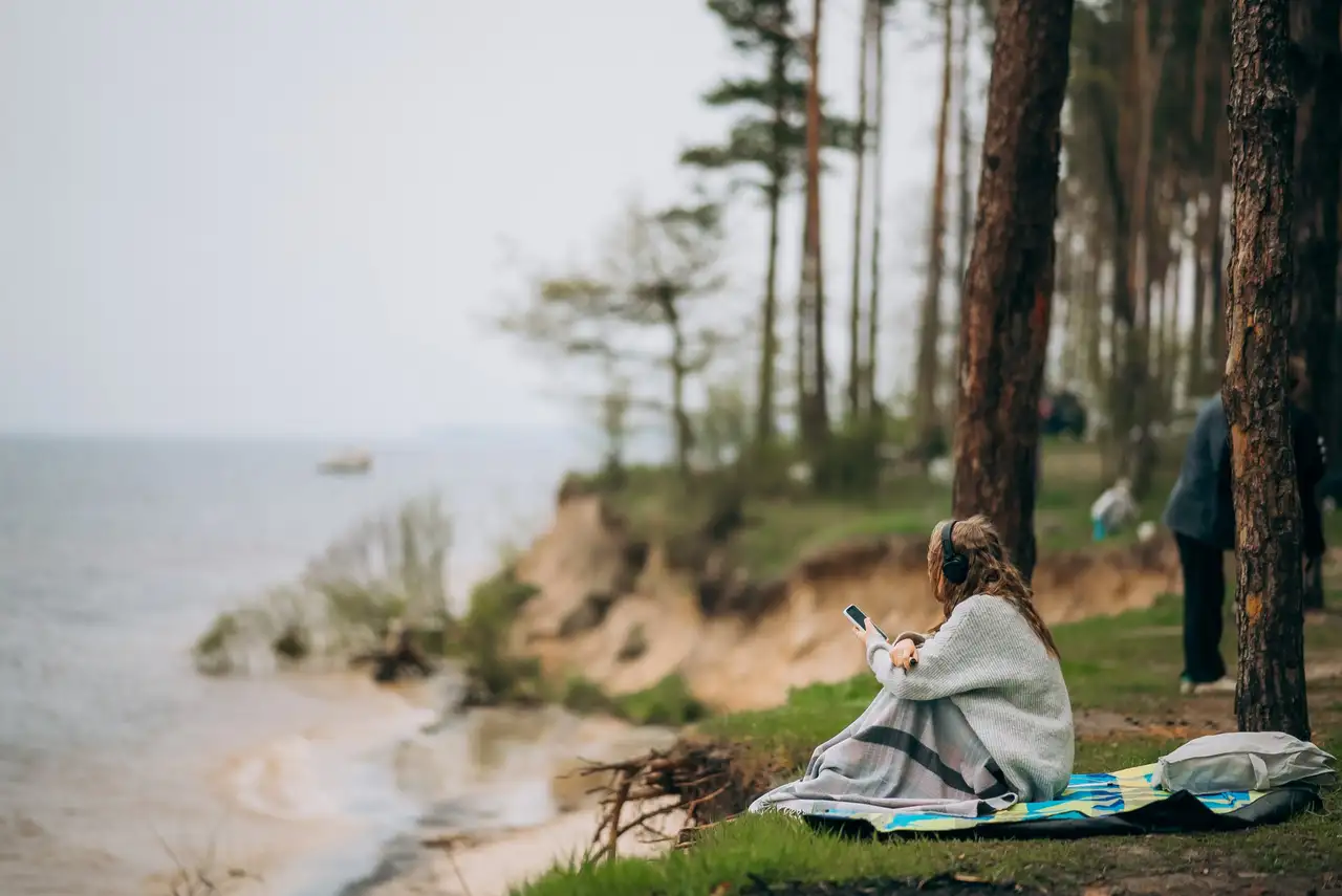 Frau sitzt am Meer in Dänemark