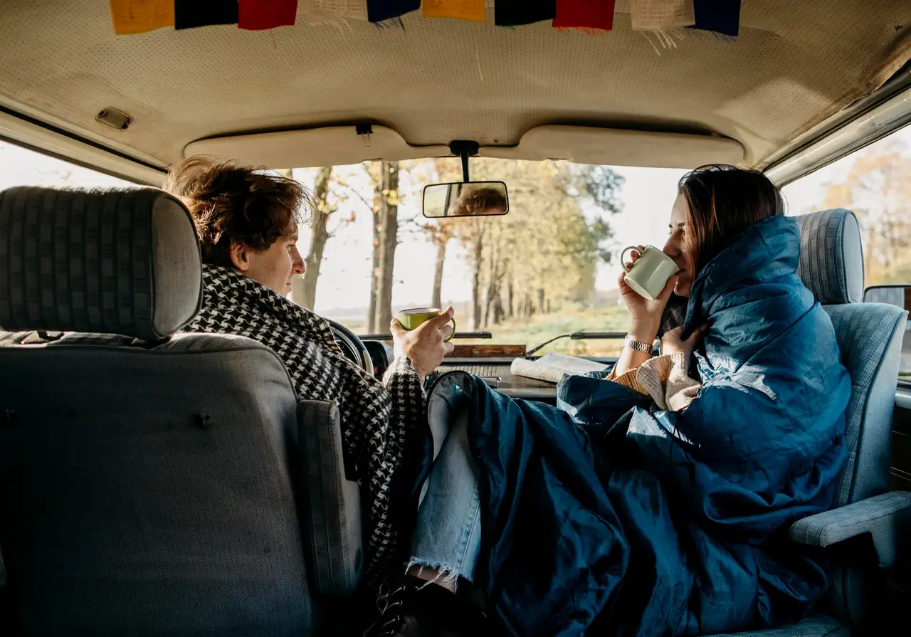 Pärchen mit Wohnmobil, Kaffeetassen und Decken