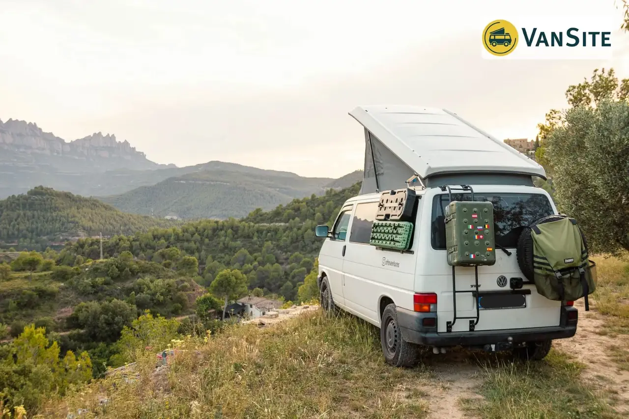 Weißer Van mit Dachzelt auf Hügel schaut auf Weite Kataloniens