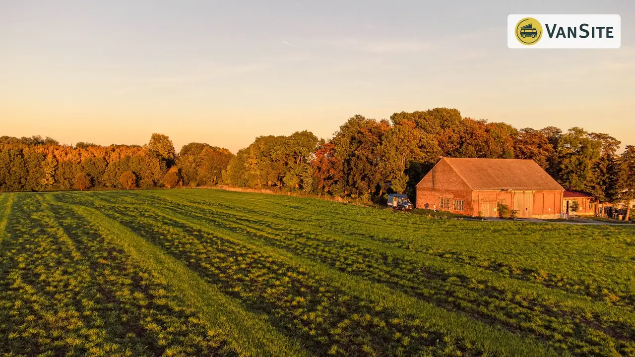 Blick auf ein Feld mit einem Haus an der rechten Seite und einem Platz