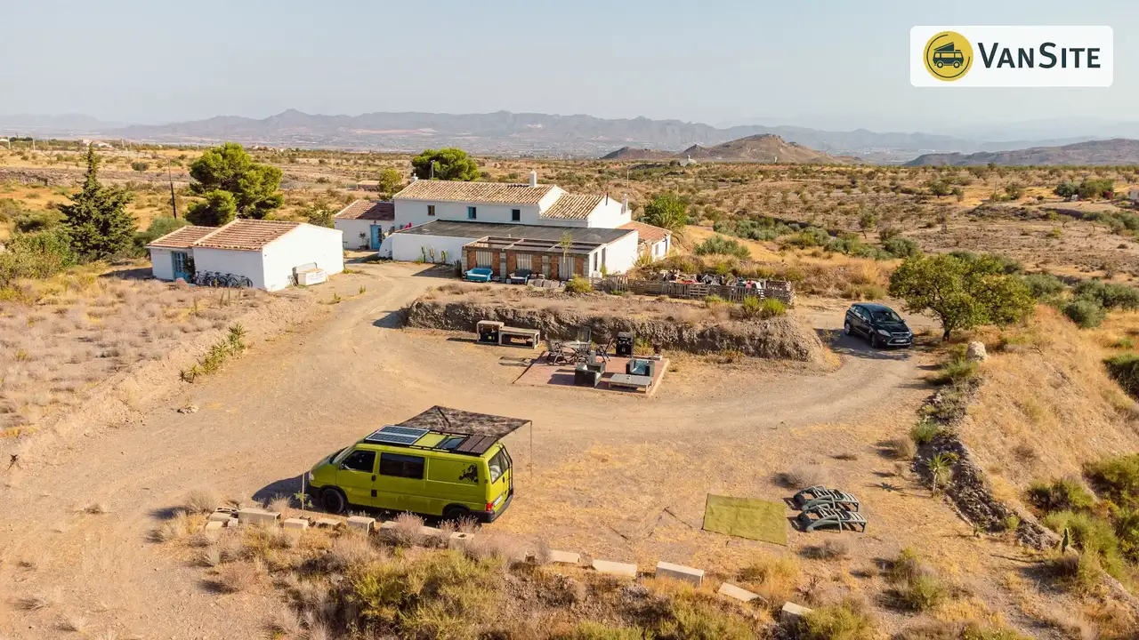 Weitblick auf die spanische Vegetation und ein Häuschen mit Vans davor
