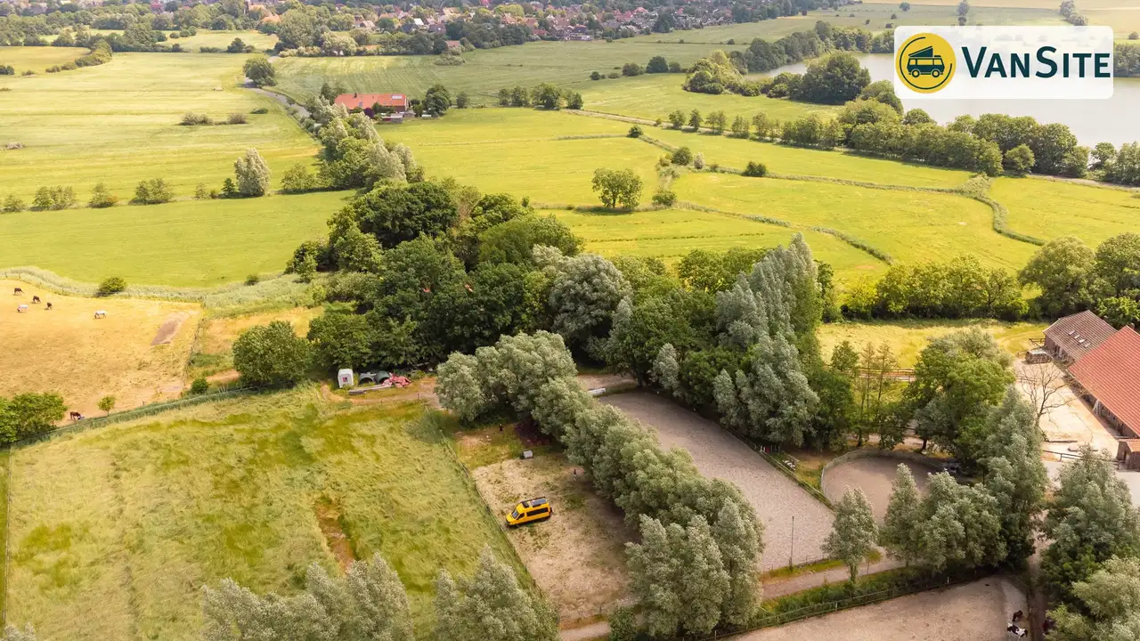 Gelber Camper steht auf einem Feld, Blick von oben