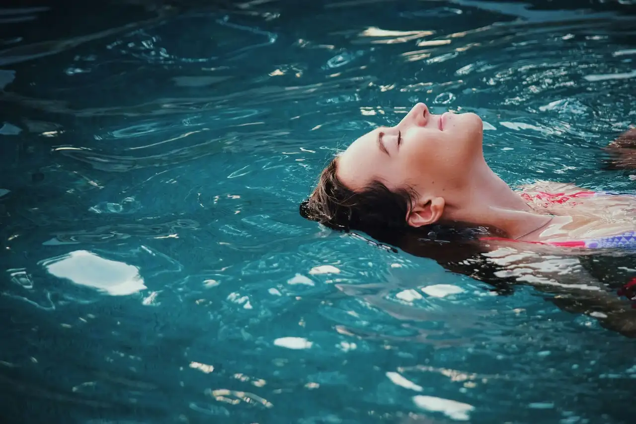 Frau beim Rückenschwimmen im Pool