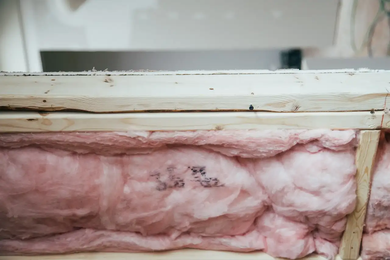 Rosafarbenes Dämmmaterial in einem Holzrahmen.