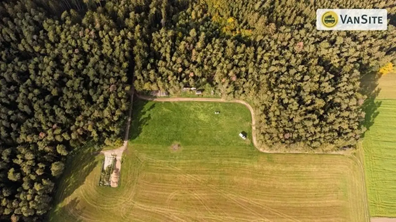 Drohnenaufnahme von einem Naturstellplatz am Waldrand