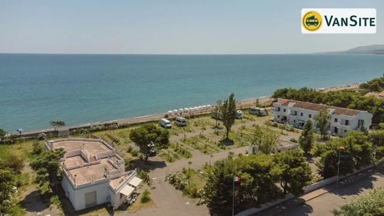 Drohnenaufnahme von grünen Wohnmobilstellplätzen direkt am Meer