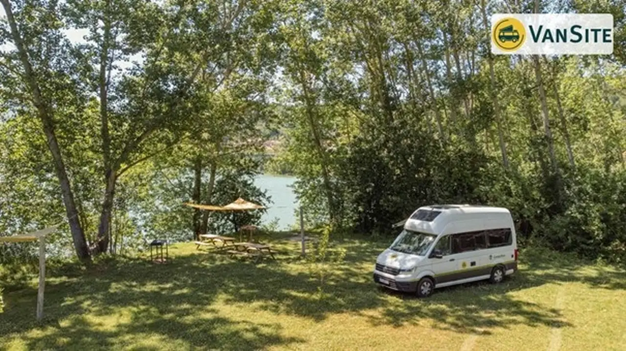 Van steht an einem See, links eine Picknick-Area