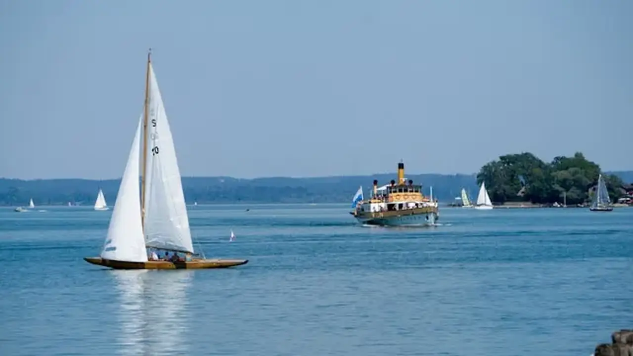 Segelboote und ein weiteres Schiff fahren auf dem Chiemsee