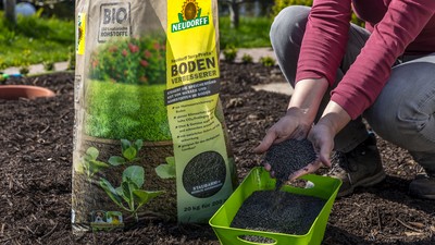 Bodenverbesserer-Packung und Frau zeigt Produkt