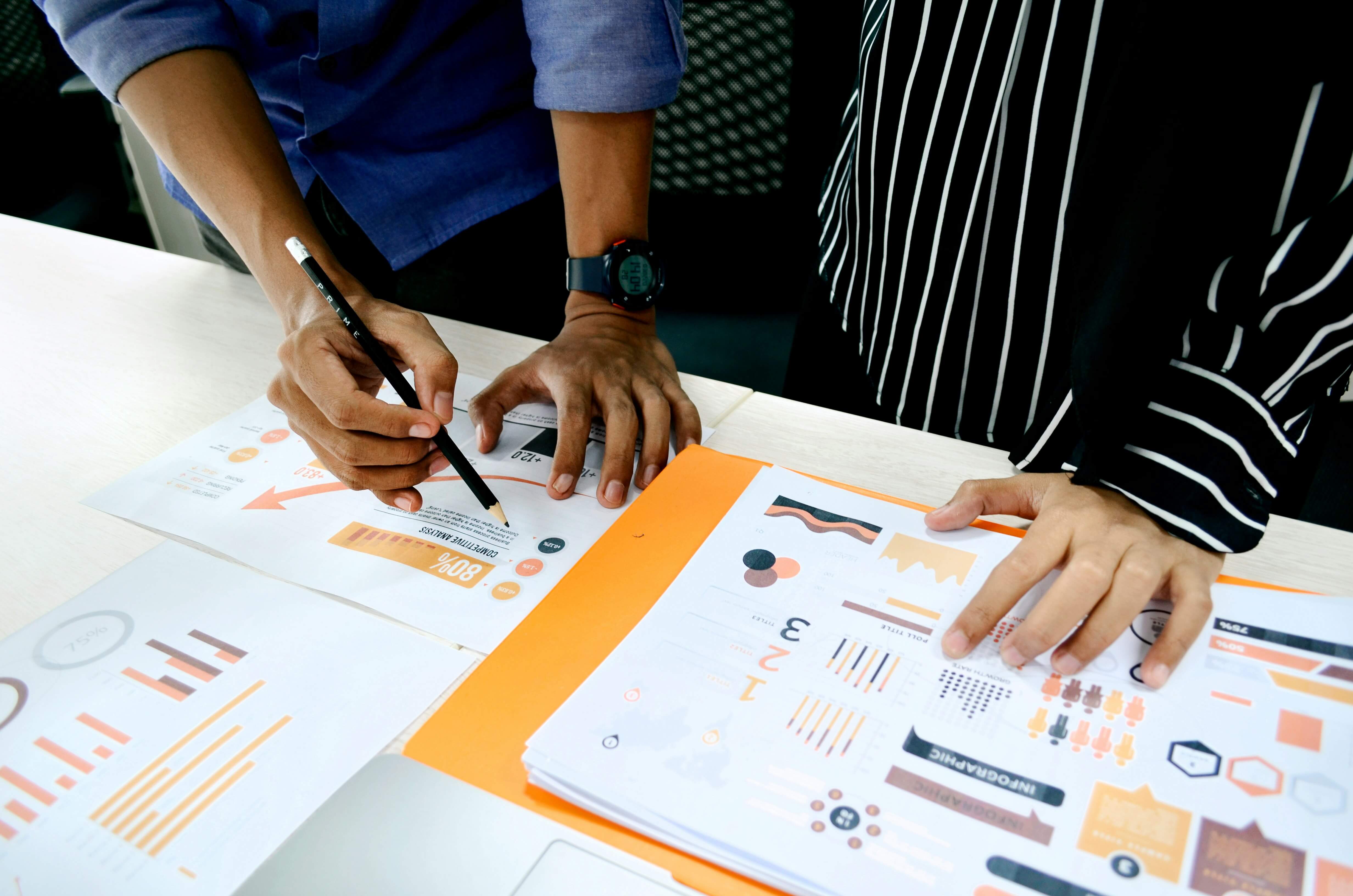 A business owner and colleague looking at market research in the form of graphs and charts.