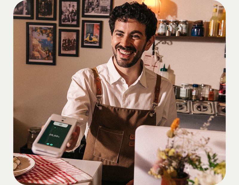 Camarero cobrando con el datáfono Go en la mesa — servicio ágil con JRPRO en toda España