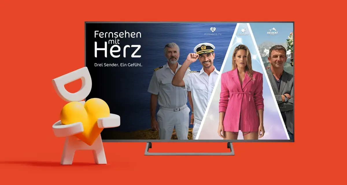 Auf einem Fernsehbildschirm sind drei Personen zu sehen, dazu der Text „Fernsehen mit Herz“. Neben dem Bildschirm steht eine Person, die ein gelbes Herz in der Hand hält. Der Hintergrund ist orange.