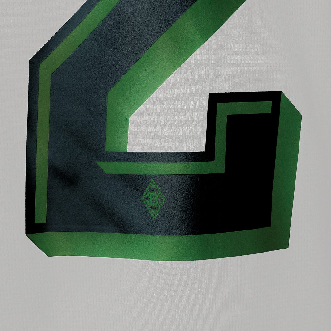 Large black and green number "2" with a diamond-shaped logo on a white fabric background.