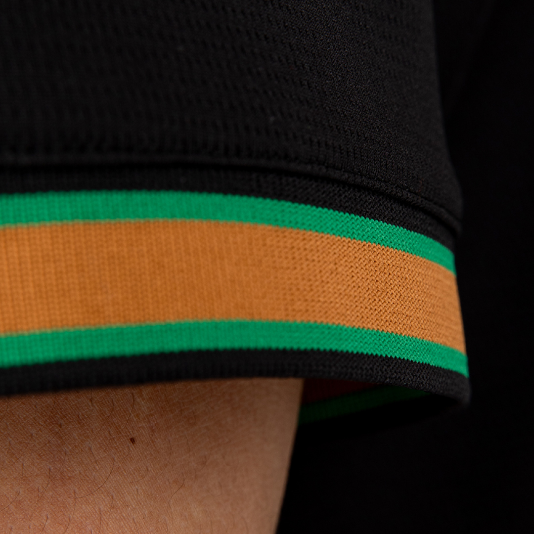 Close-up of a black sleeve with orange and green stripes.