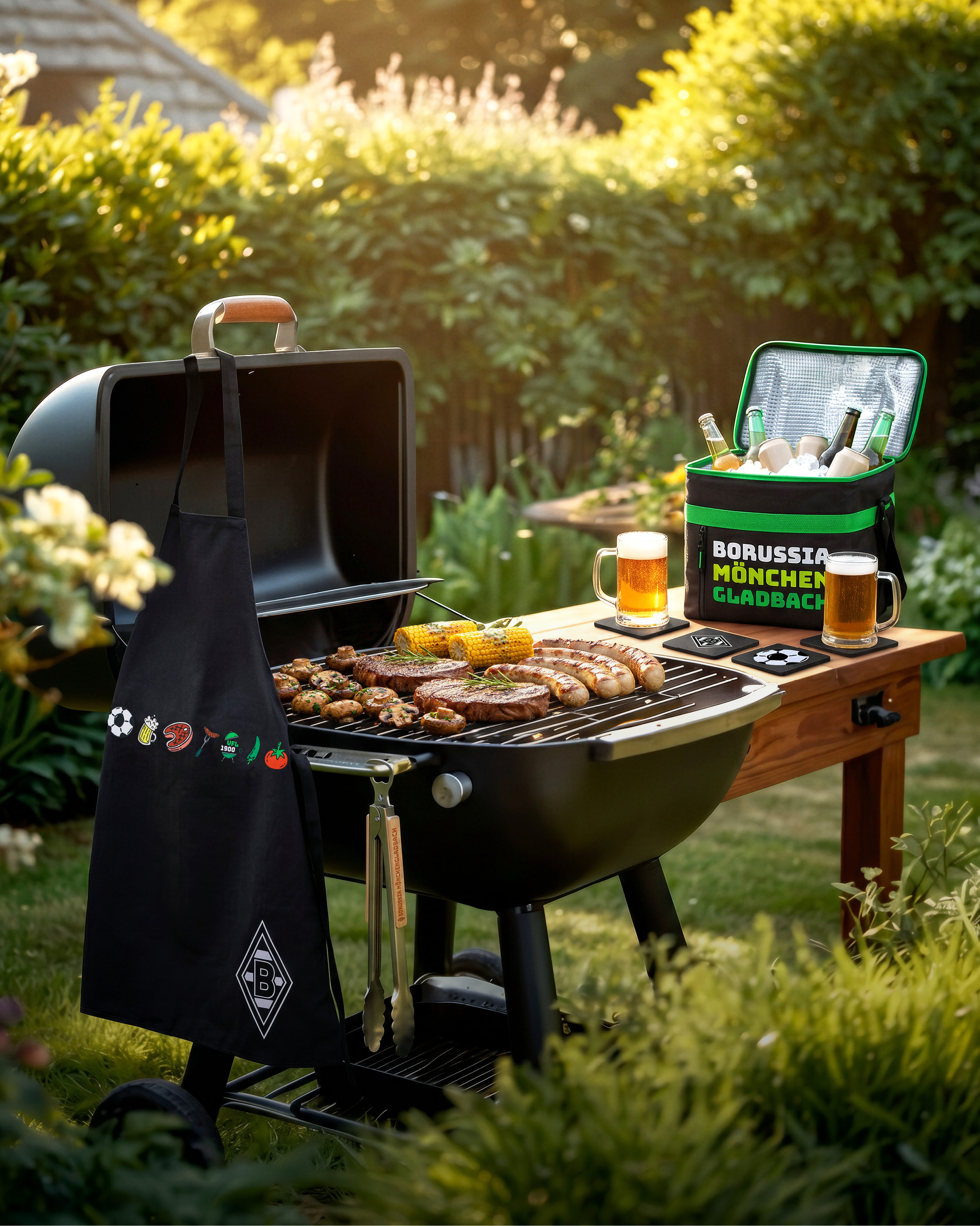 Grill with meat and corn, apron, and cooler with drinks in a garden setting. Sunlit and surrounded by lush greenery.