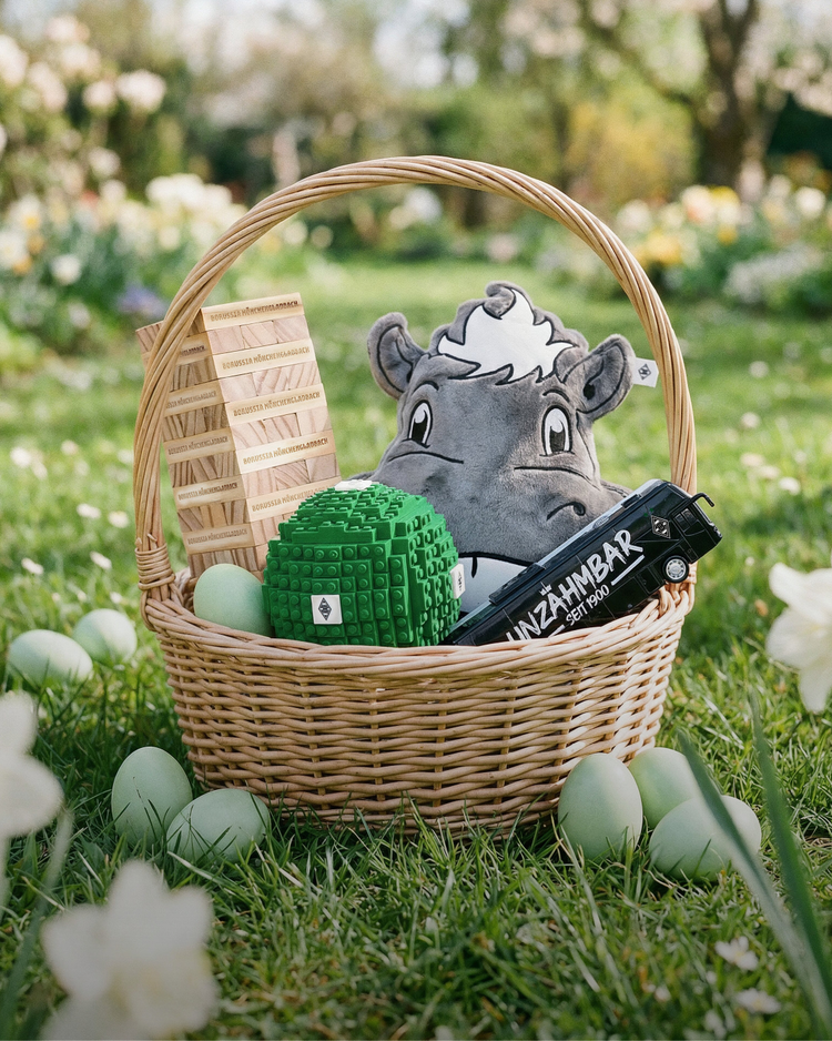 Wicker basket on grass with a plush hippo, wooden structure, green block, and black toy car surrounded by pastel green eggs.