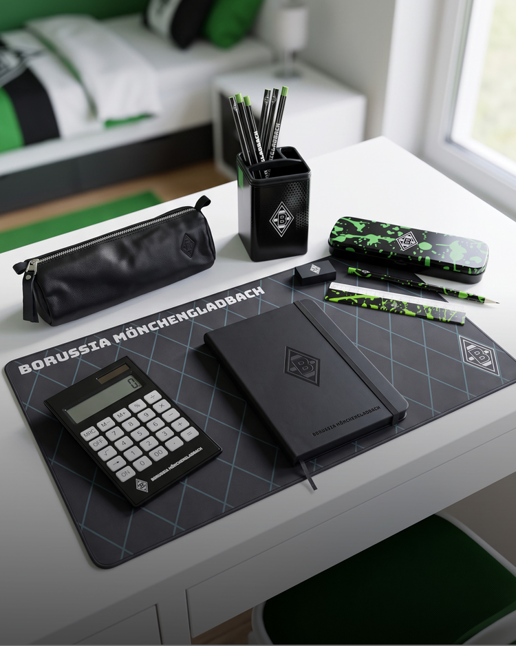 Desk with Borussia Mönchengladbach stationery set, including a notebook, calculator, pencil case, pens, pencils, and desk mat, in a modern bedroom.