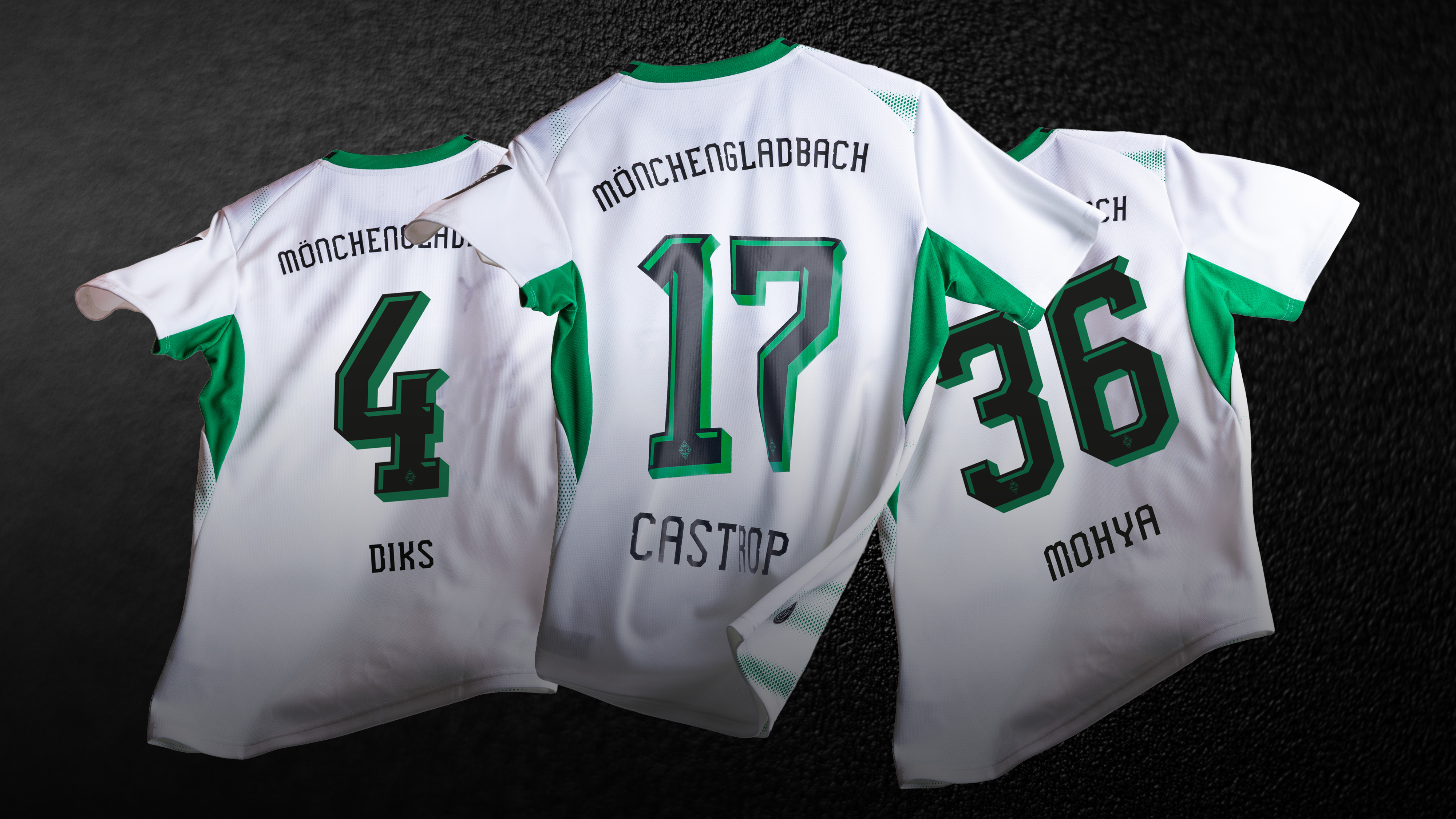 Three Borussia Mönchengladbach soccer jerseys, numbered 4, 17, and 36, displayed from the back on a dark surface.