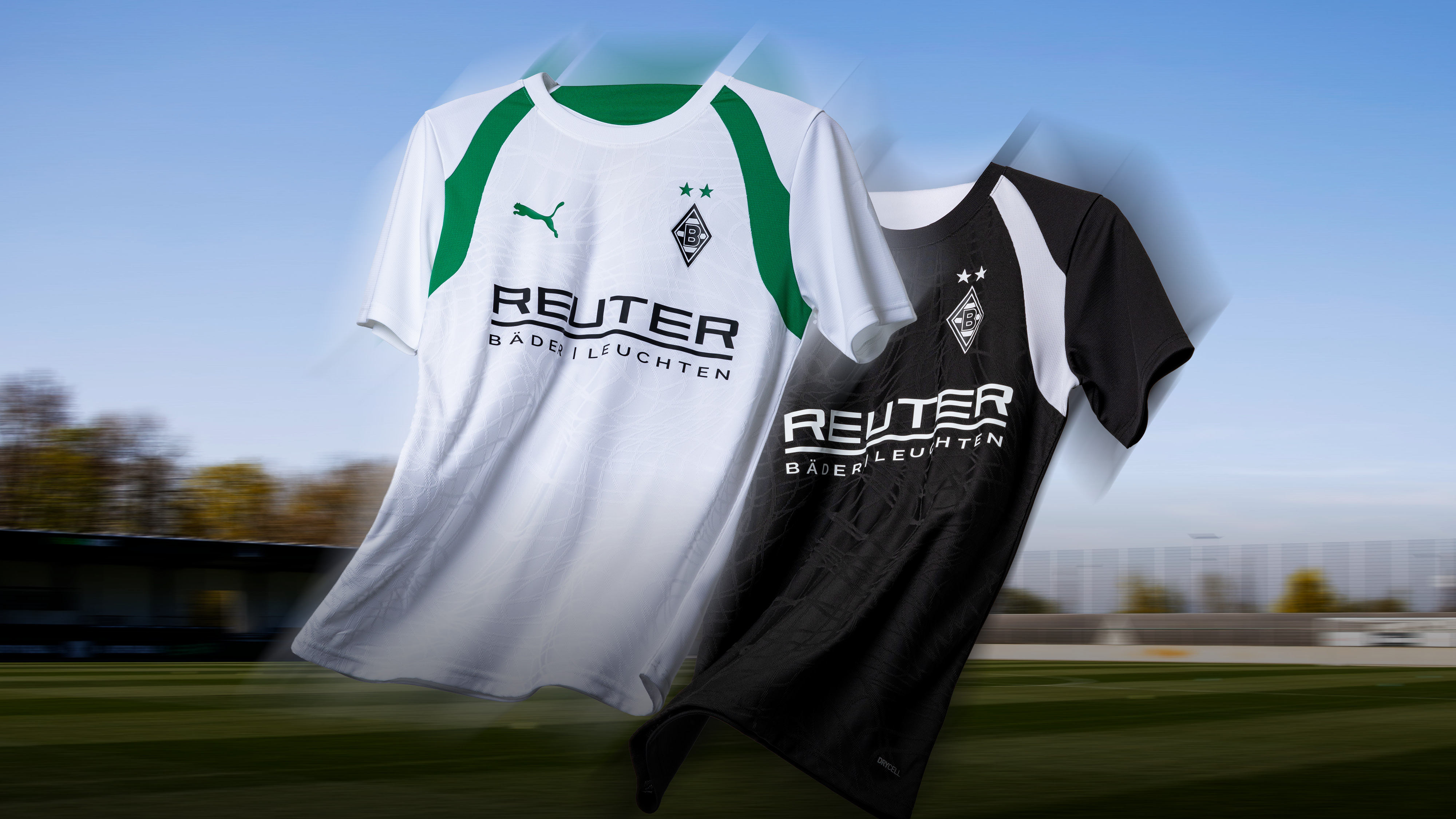 Two Puma soccer jerseys with team logos, one white with green accents and the other black with white accents, against an outdoor backdrop.
