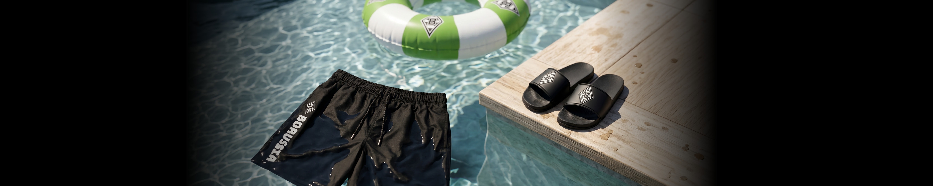 Black sandals and shorts on a wooden deck by a pool with a green and white inflatable ring floating in the water.
